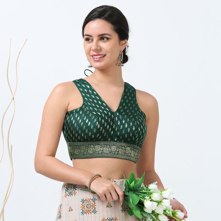 Enhance your saree ensemble with our Zari Work Silk Saree Blouse, a stunning piece that combines traditional craftsmanship with contemporary convenience. This readymade blouse is meticulously designed with intricate zari work, adding a touch of opulence and elegance to your look. Crafted from high-quality silk, it boasts a luxurious feel and a flattering fit, making it an ideal choice for special occasions and celebrations. The blend of rich fabric and exquisite embroidery ensures that you radia Festive Green Sleeveless Blouse Piece, Elegant Green Blouse With Zari Weaving, V-neck Choli With Pallu For Puja, Traditional V-neck Blouse Piece For Diwali, Traditional V-neck Blouse For Diwali, Traditional V-neck Saree For Puja, Festive Green V-neck Blouse, Green Blouse With Zari Weaving For Puja, Green Blouse With Zari Weaving For Navratri