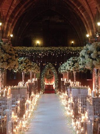 the aisle is decorated with candles and flowers