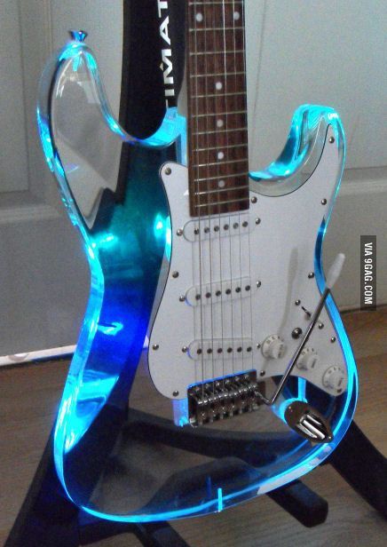 an electric guitar with blue lights on it's body and neck is sitting on a stand