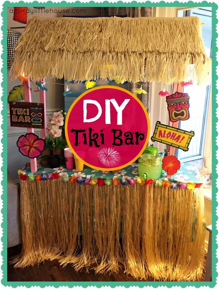 a woman sitting at a table in front of a tiki hut filled with drinks