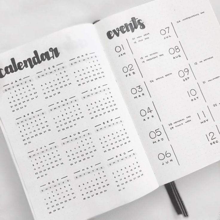 an open calendar book with black numbers on the page and pen in front of it