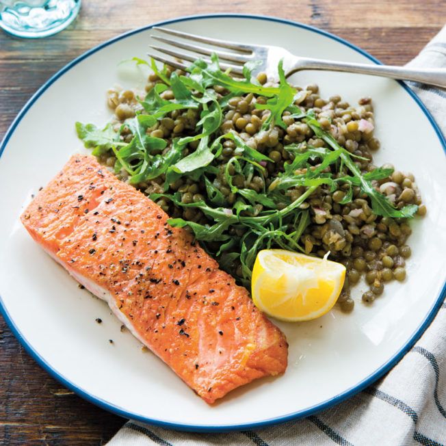 salmon and lentils on a plate with a fork