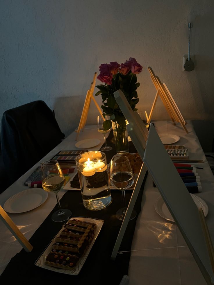 the table is set up with candles and desserts for two people to eat together