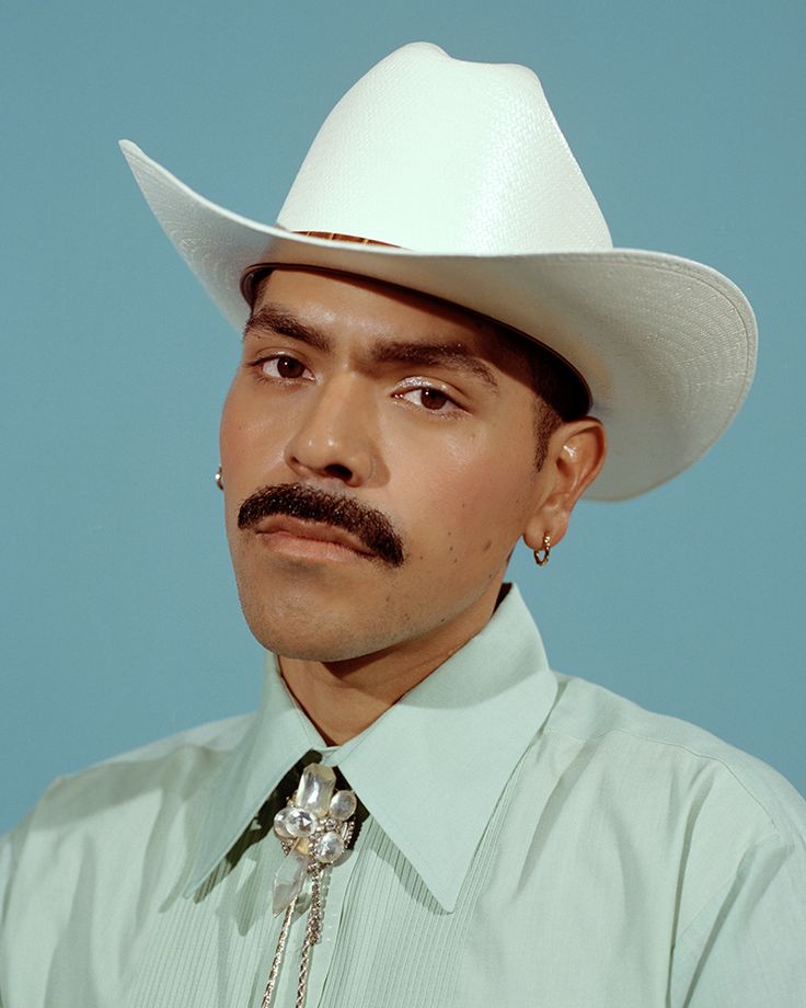 a man wearing a white cowboy hat and tie