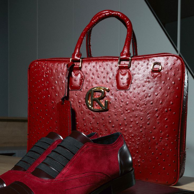 a pair of red shoes sitting next to a red bag