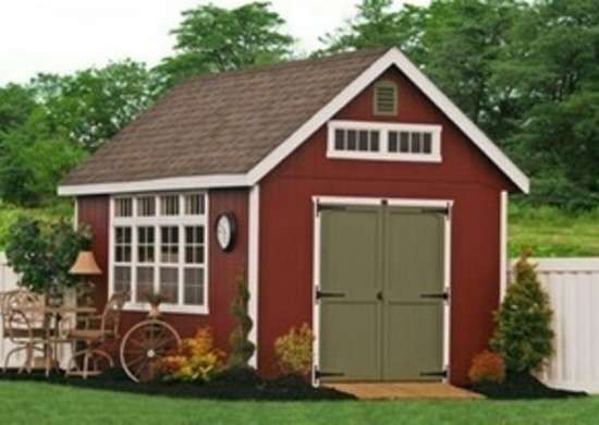 a red shed with a bicycle parked in front of it and flowers around the door