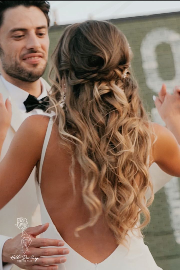 Bride has nice hairstyle for wedding day as she dances with groom Long Hair Pulled Back Half Up, Happy Up Half Down Wedding Hair, Wedding Hairstyles Half Up Half Down Bubble Braid, Wedding Hair Half Pinned Back, Half Up Bun Wedding Hair, Easy Cute Girls Hairstyles, Wavy Hair Pulled Back Half Up, Half Down Bridal Hair, Down Bridal Hair