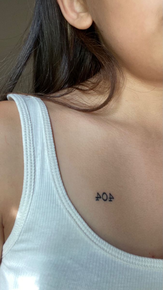 a woman with a small tattoo on her upper arm and chest that reads 404