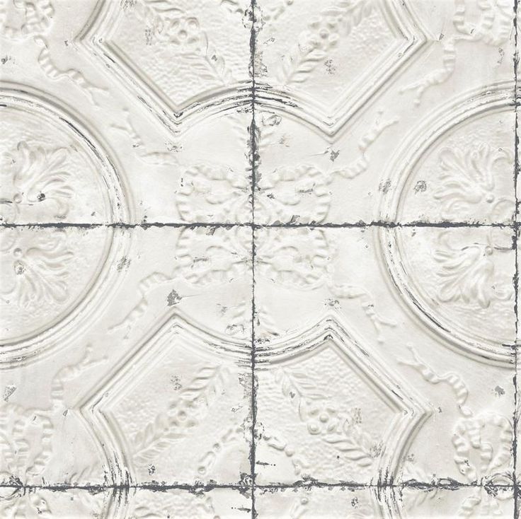 a white tile wall with an intricate design on it