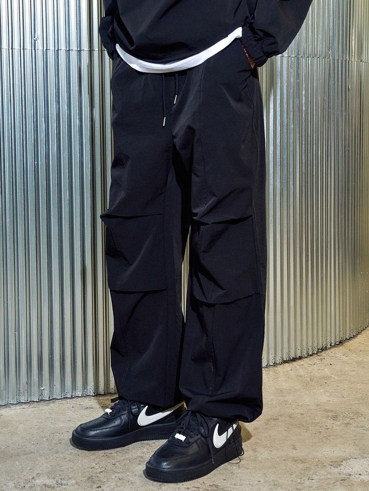 Editor's notesIt is a casual parachute pant for unisex. Made of dense heavyweight nylon spandex fabric  the pant is waterproof and has comfy fit. The pant has parachute design point on the front and double stitching for durable finish. The silhouette of the pant is adjustable using drawcords on the hem. - Elastic waist with drawstring- Side pockets- Patched back pocket- Spandex blend fabricMeasurements(in.)Size 1 / Size 2- Length: 39.8 in. / 40.9 in.- Waist: 13.8 in. / 14.2 in.- Thigh: 13 i Urban Style Baggy Parachute Pants For Outdoor, Practical Black Pants For Outdoor, Nylon Cargo Pants With Pockets In Techwear Style, Black Utility Parachute Pants For Hiking, Black Practical Pants For Outdoor Activities, Baggy Black Parachute Pants For Outdoor, Practical Black Cargo Pants For Hiking, Practical Black Pants For Outdoor Activities, Black Baggy Parachute Pants For Outdoor