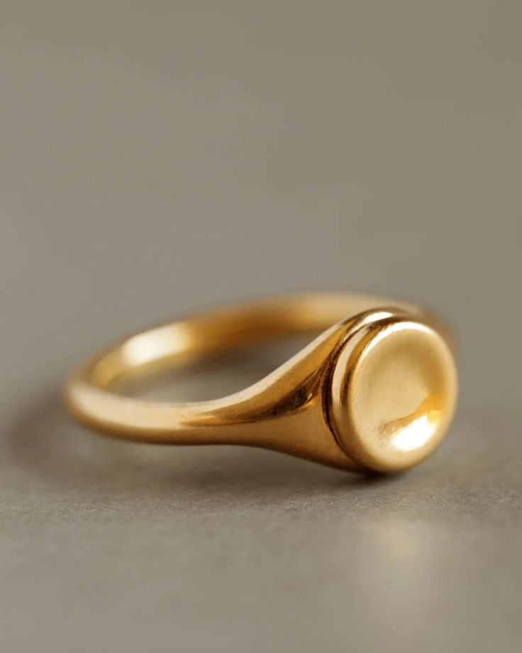 A round button of gold, gently pressed atop a noble signet ring. With refined proportions and a simplified silhouette, the Button Ring is a modern signifier of strength, integrity, and wholeness. Ideal as a wedding band, a milestone ring, or for everyday wear. Each ring is stamped with the George Rings™ crown. Solid 18k yellow gold. 8.5mm button diameter. Handmade in Portland. Ships approximately 4 weeks after receipt of your order. Gold Signet Ring With Bezel Setting For Everyday, Timeless Everyday Initial Ring, Minimalist Yellow Gold Signet Ring With Bezel Setting, Timeless Wedding Signet Ring With Smooth Bezel, Classic Signet Ring With Bezel Setting For Everyday, Classic Everyday Signet Ring With Bezel Setting, Timeless Round Signet Ring Tarnish Resistant, Classic Bezel-set Signet Ring For Everyday, Timeless Everyday Signet Ring With Smooth Bezel