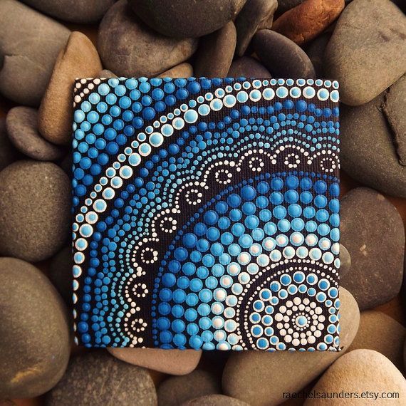 a blue and white painting sitting on top of some rocks