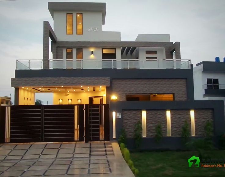 a modern house is lit up at night with lights on the front and side windows