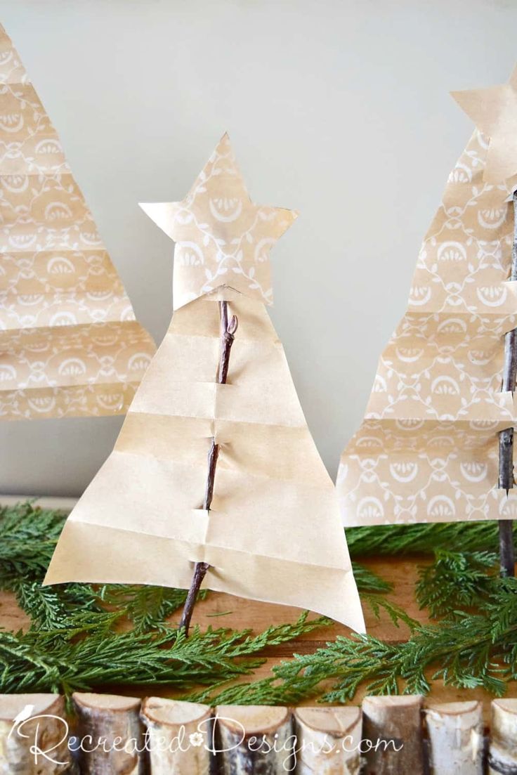 three paper christmas trees sitting on top of a table