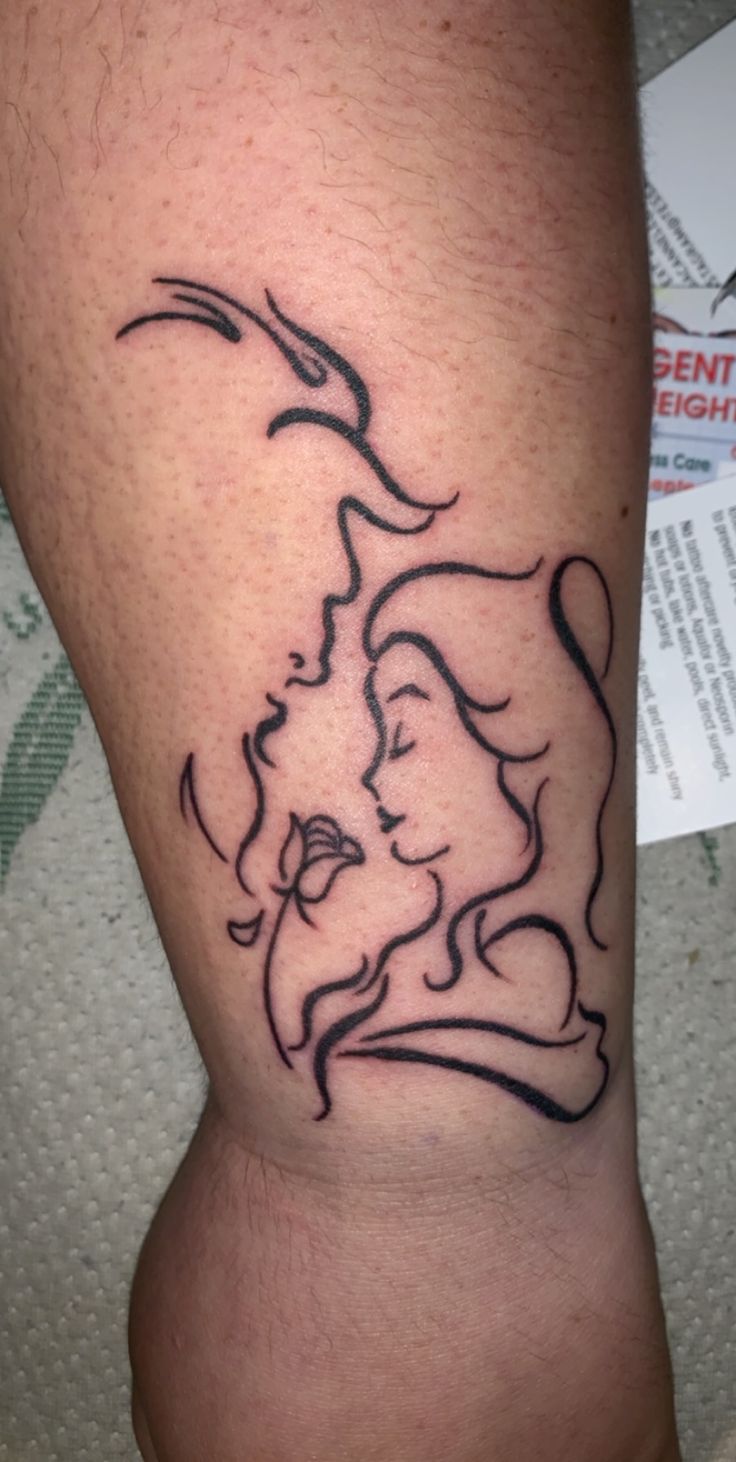 a woman's leg with a tattoo on it that has an image of two women