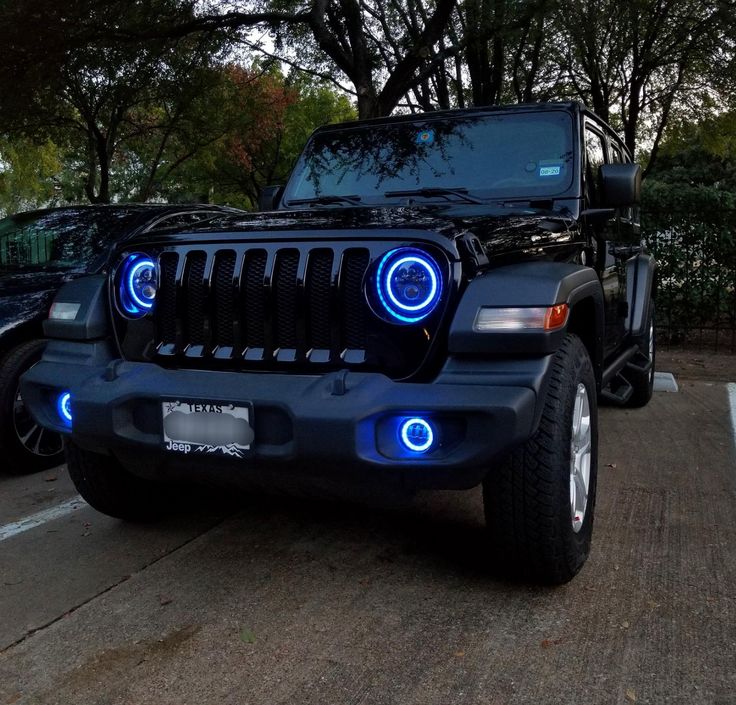 a black jeep with blue leds parked on the street