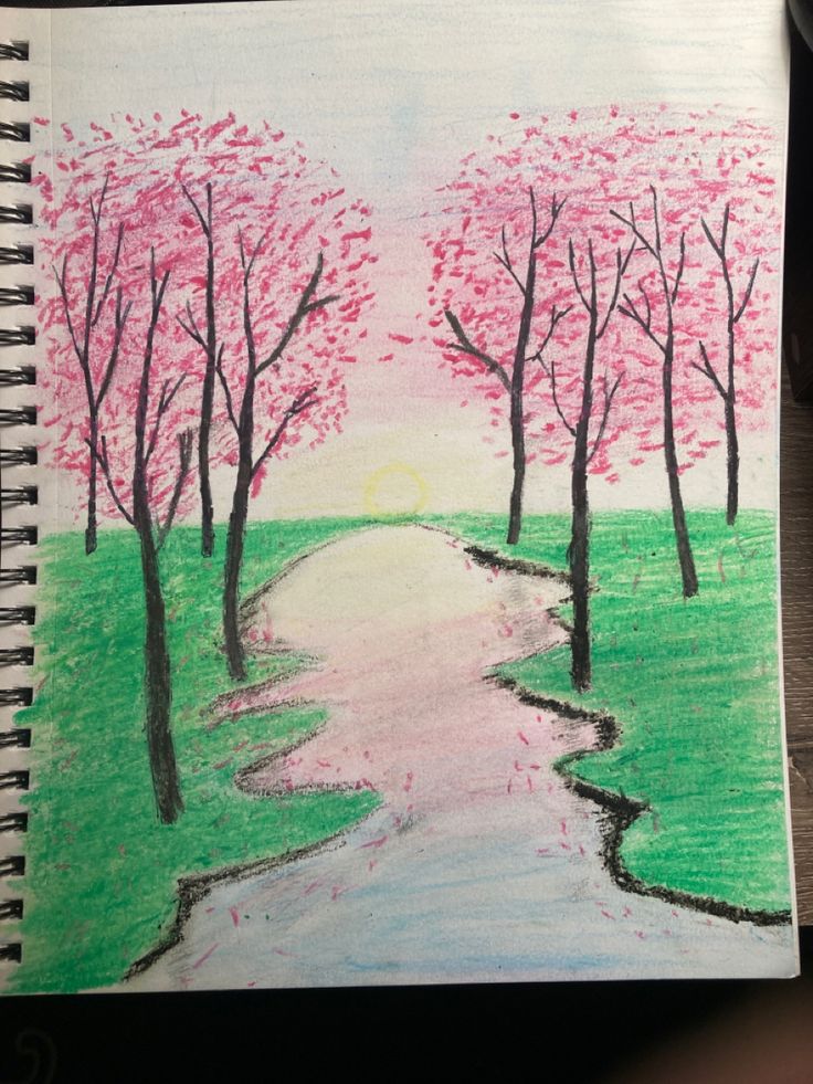 a drawing of a river and trees with pink flowers in the background on a notebook