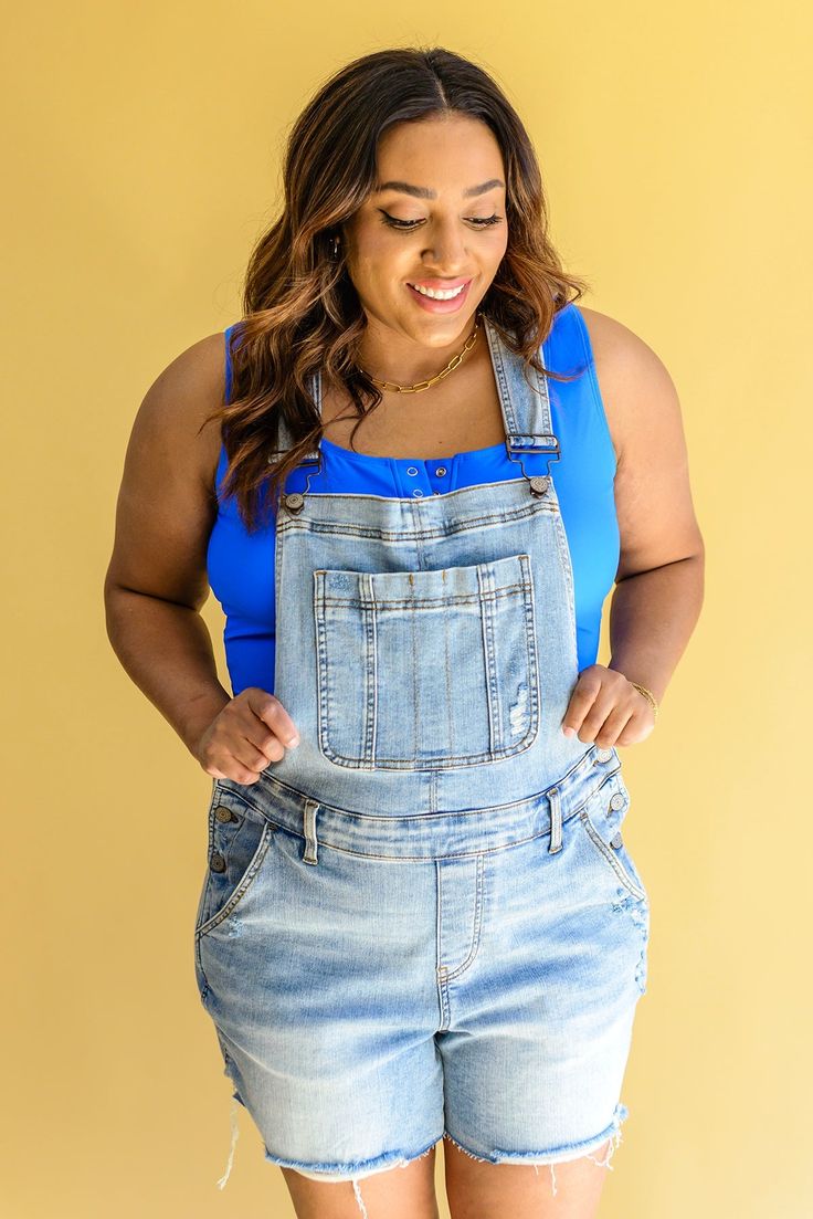 Step into summer style with Devon Distressed Shortalls! These stylish bib front overalls are designed with adjustable straps, mid-rise shorts, a light wash, and distressing. Plus, the cut off hem gives them a modern, edgy look. Are you ready to add some inspiring summer fashion to your wardrobe? Try on Devon Distressed Shortalls today! Judy Blue Adjustable Straps Side Buttons 4-Way Stretch Raw Hem 91.4% Cotton, 7.4% Polyester, 1.2% Spandex True to Size S: Waist 29" Hips 39" Inseam 4" Torso 27"-3