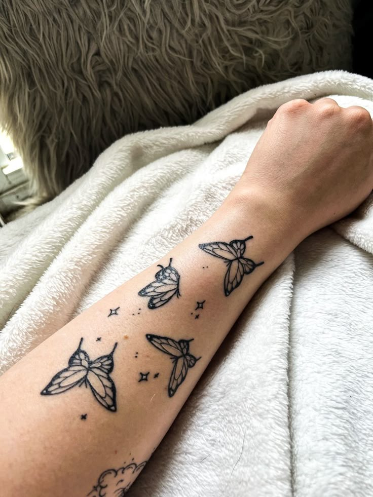 a person with a tattoo on their arm that is flying in the sky and stars