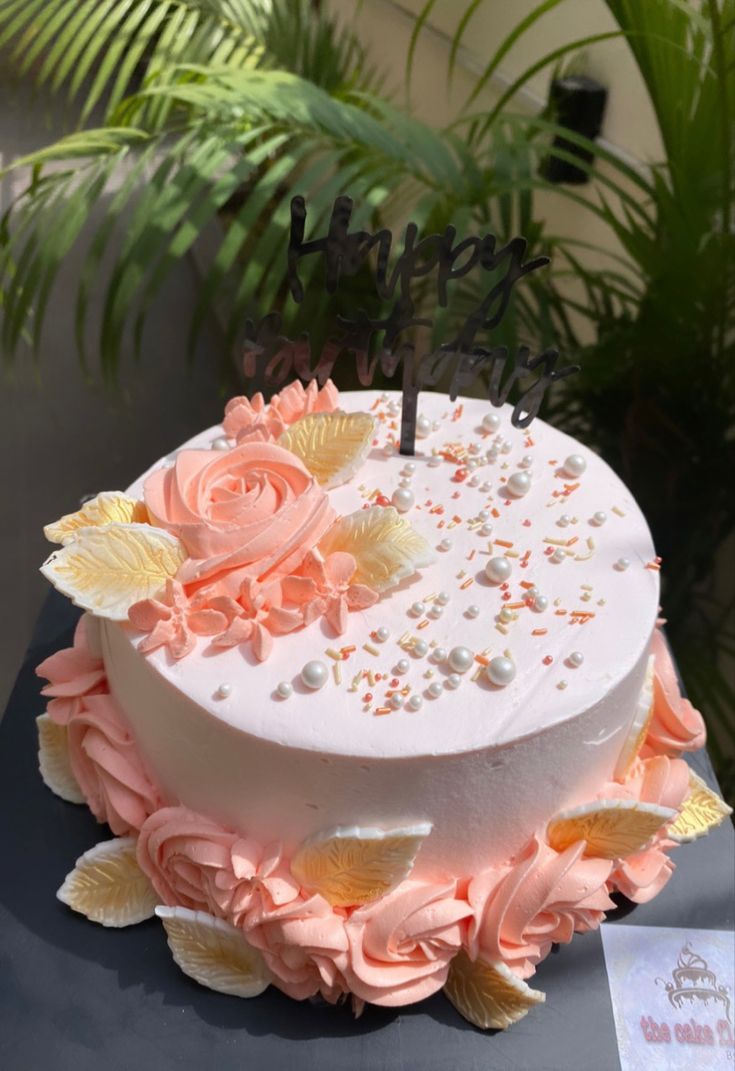 a white cake with pink and yellow flowers on it