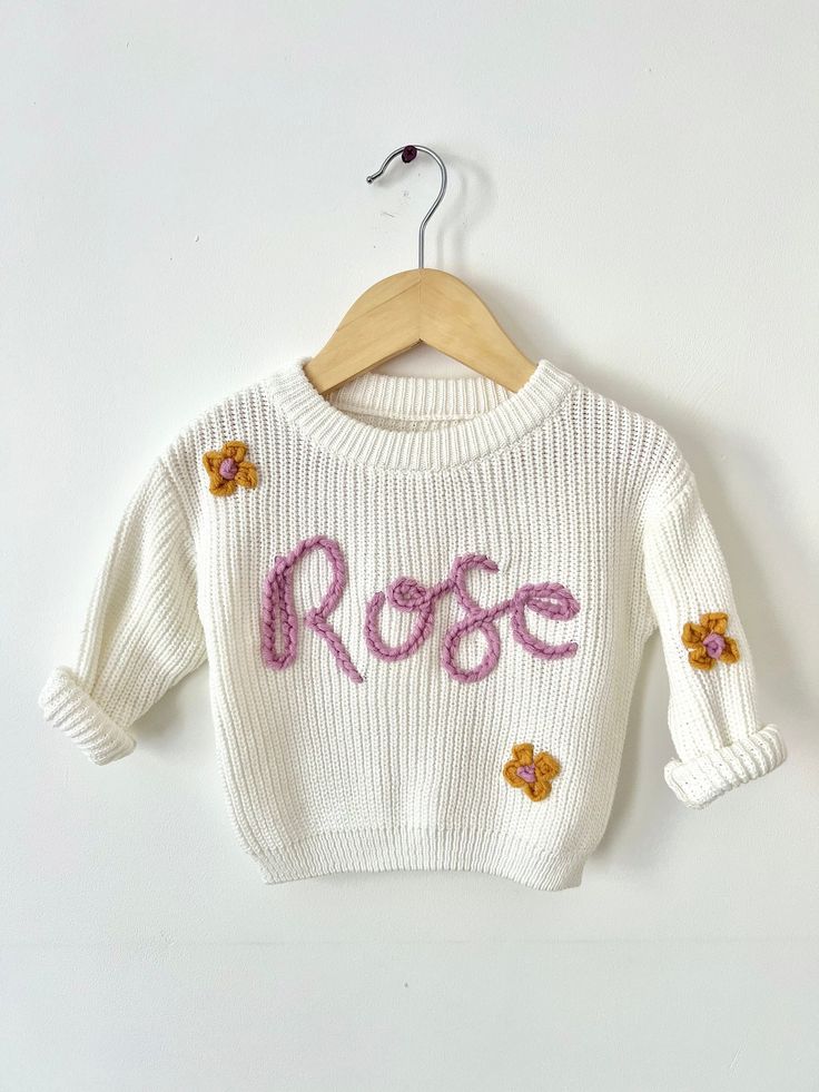 Hand embroidered children's knit sweater  Perfect for newborn/family photos, birth announcements, baby shower gift, or any occasion! Name or word is hand stitched in cursive writing and may vary. A simple customizable item where you choose the sweater colour, yarn colour, and name/word to make the cutest gift. Sweaters are 100% cotton and oversized, leaves room to grow and able to wear for longer in my opinion! In the pictures, Lily is 15 months and is wearing size 9-12 months and it fits just right! Yarn colour can either be a single colour or alternating, just specify which in personalisation box.  I do flower and heart designs as well! They would go over any i's or j's and/or off to the side. Just select w/design under 'letter count and design' option. And specify which in personalisati Cute White Sweater With Custom Embroidery, White Cute Sweater With Custom Embroidery, Cute White Embroidered Sweater, Spring Knit Sweater With Letter Print, Personalized White Sweater For Winter, White Sweater With Custom Embroidery, Handmade White Cotton Sweater, White Cute Sweater With Embroidered Text, Personalized White Cotton Sweater