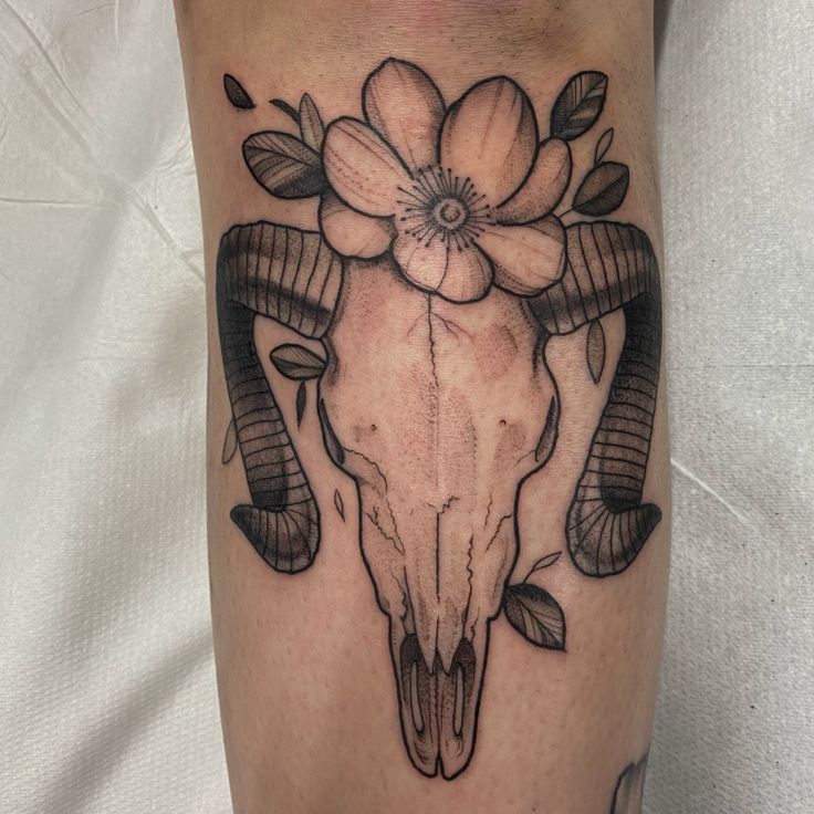 a bull skull with flowers on it's side