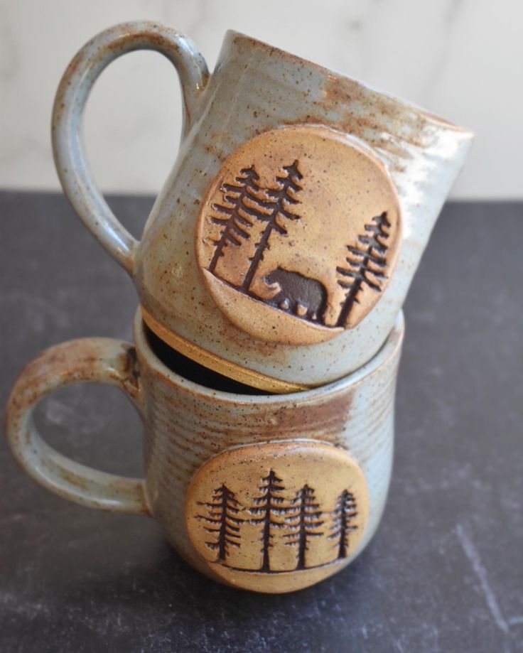 two ceramic mugs with trees on them