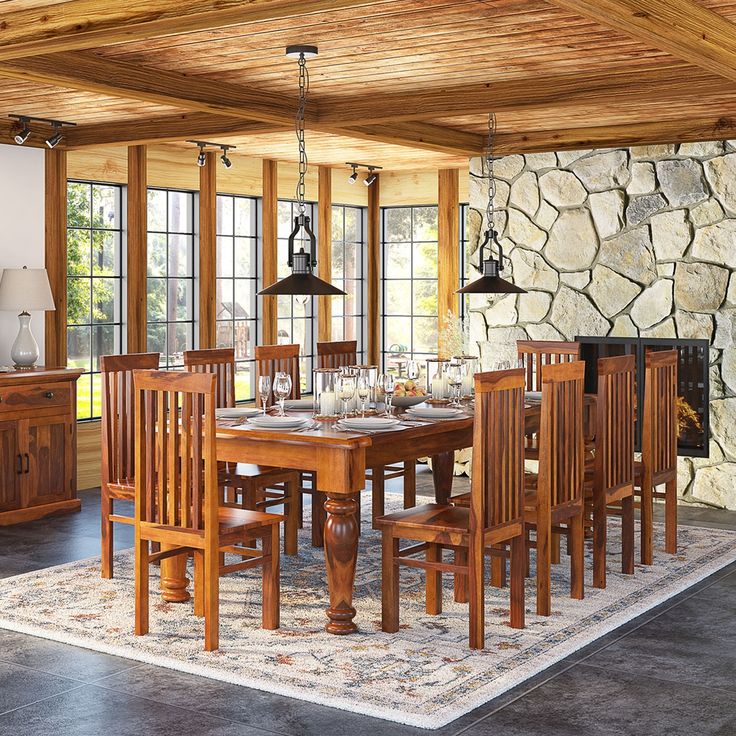 a dining room table and chairs in front of a stone wall with wood trimming