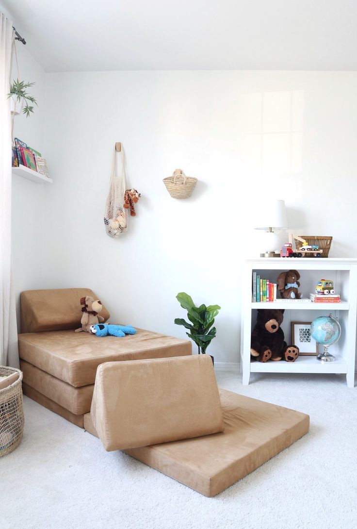 a child's room with two brown chairs and a book shelf on the wall