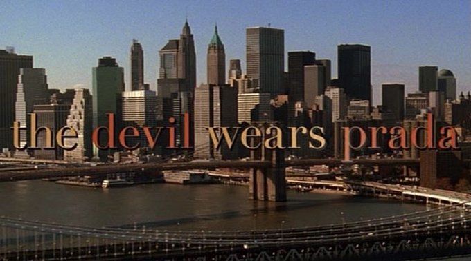 the devil wears prada sign is in front of a cityscape and bridge