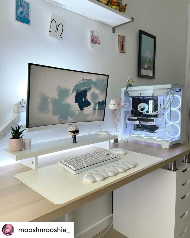 a desk with a computer monitor, keyboard and mouse on it in front of some pictures