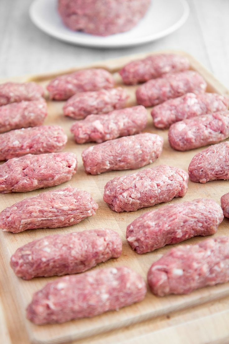 raw hamburger patties on a cutting board ready to be cooked