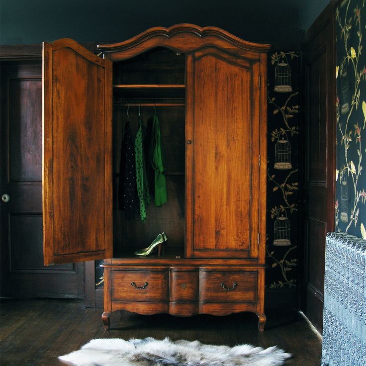 a wooden armoire sitting next to a closet