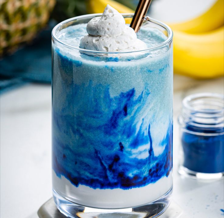 a blue drink with whipped cream on top