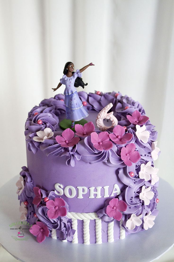 a purple cake with flowers and a girl on top that says sophia in white lettering