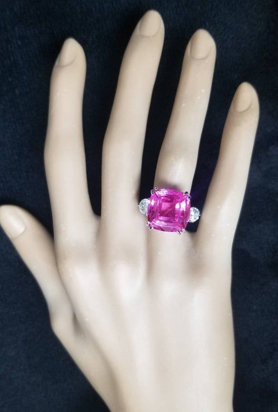 Gorgeous Vintage cushion cut  pink sapphire set in 14k white gold engagement ring center cushion shape lab grown  pink sapphire weight 14.90ct size 14x14mm gorgeous bubblegum pink color  ,very lively ,very sparkly ,nice setting. very clean the color  is superb pink ,very brilliant stone.side two natural  round diamonds weight 1.17ct size 5.2mm SI1-HRing size 7Resizable Appraisal available Retail value $9,500 net. Cushion Cut Pink Cubic Zirconia Jewelry, Pink Cushion Cut Cubic Zirconia Jewelry, Radiant Cut Pink Jewelry With Accent Stones, Pink Radiant Cut Jewelry With Accent Stones, Pink Cushion Cut Diamond Jewelry, Pink Cushion Cut Jewelry Gift, Pink Cushion Cut Jewelry With Prong Setting, Pink Cushion Cut Gemstone Jewelry, Pink Cushion Cut Wedding Jewelry