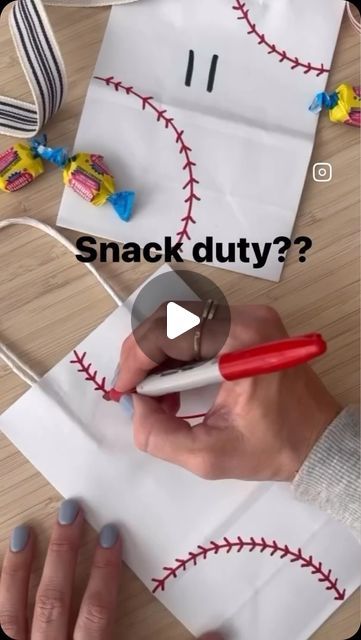 a person is making a baseball themed paper bag with candy on it and the words snack duty?