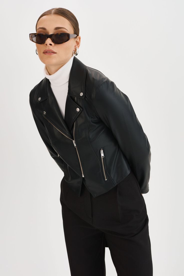 Exude confidence with the Monica Faux Leather Jacket, a true wardrobe essential for the modern woman. This classic piece features an asymmetric front zip closure, zipper pockets & notch collar. Versatile and effortlessly stylish, this jacket is perfect for both casual and formal occasions. Sleek Biker Jacket For Office In Fall, Sleek Leather Jacket With Asymmetrical Zip For Fall, Sleek Leather Jacket With Zipper Closure, Fall Leather Jacket With Zipper For Work, Trendy Asymmetrical Zip Leather Jacket For Work, Modern Fitted Outerwear With Asymmetrical Zip, Chic Biker Jacket With Zip Fly For Workwear, Sleek Fitted Outerwear With Asymmetrical Zip, Classic Outerwear With Asymmetrical Zipper Closure