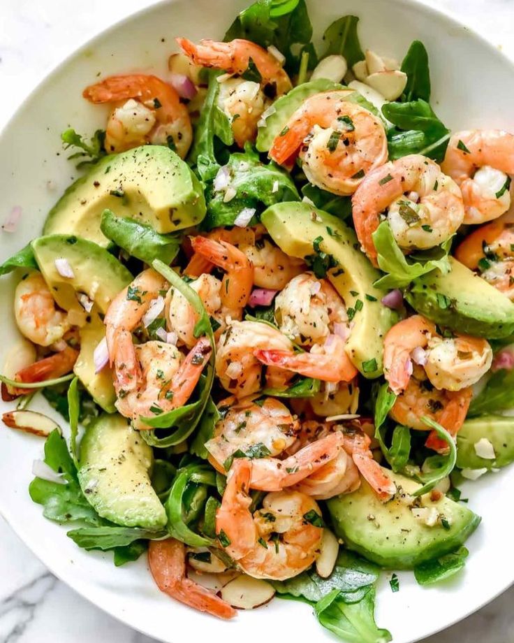 a salad with shrimp and avocado in it