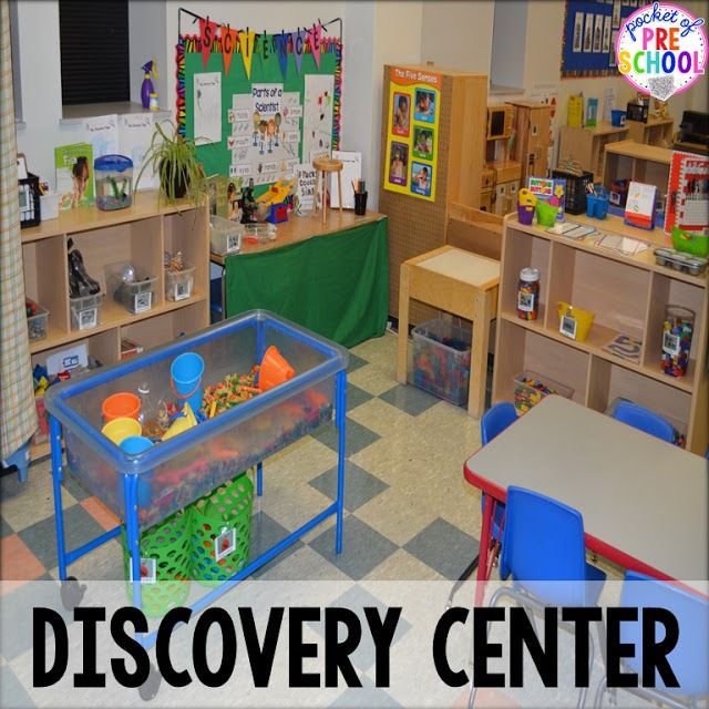 a classroom filled with lots of toys and desks next to a green sign that says discovery center