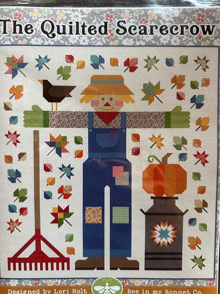 the quilted scarecrow pattern is displayed in front of a white background with an orange and