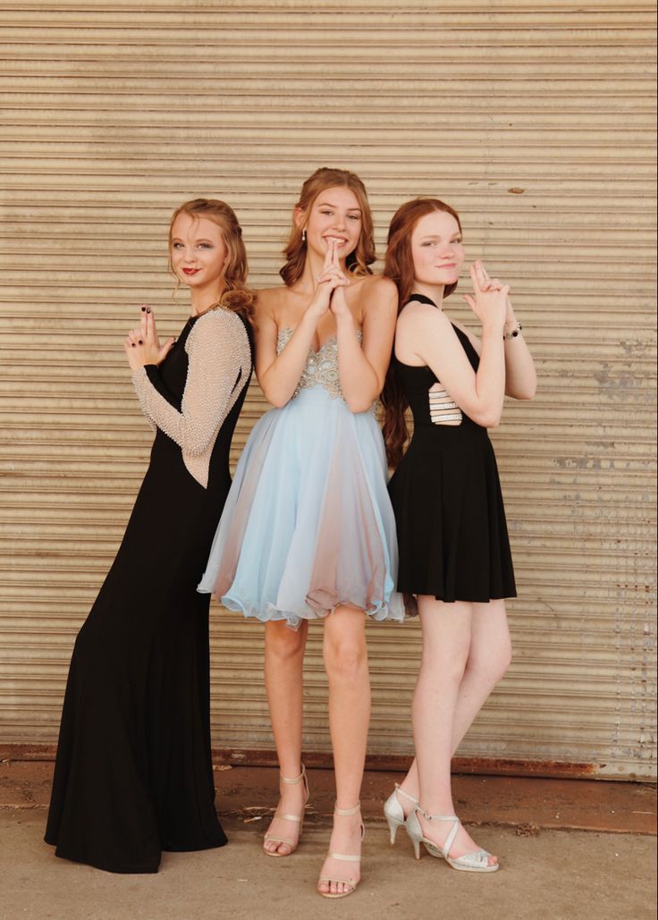 three young women standing next to each other with their hands together in front of them