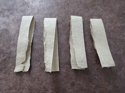 four pieces of white paper sitting on top of a table