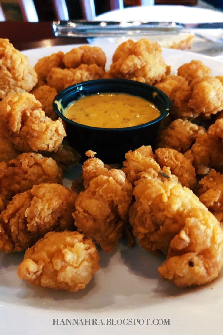 fried food on a plate with dipping sauce in the middle, ready to be eaten