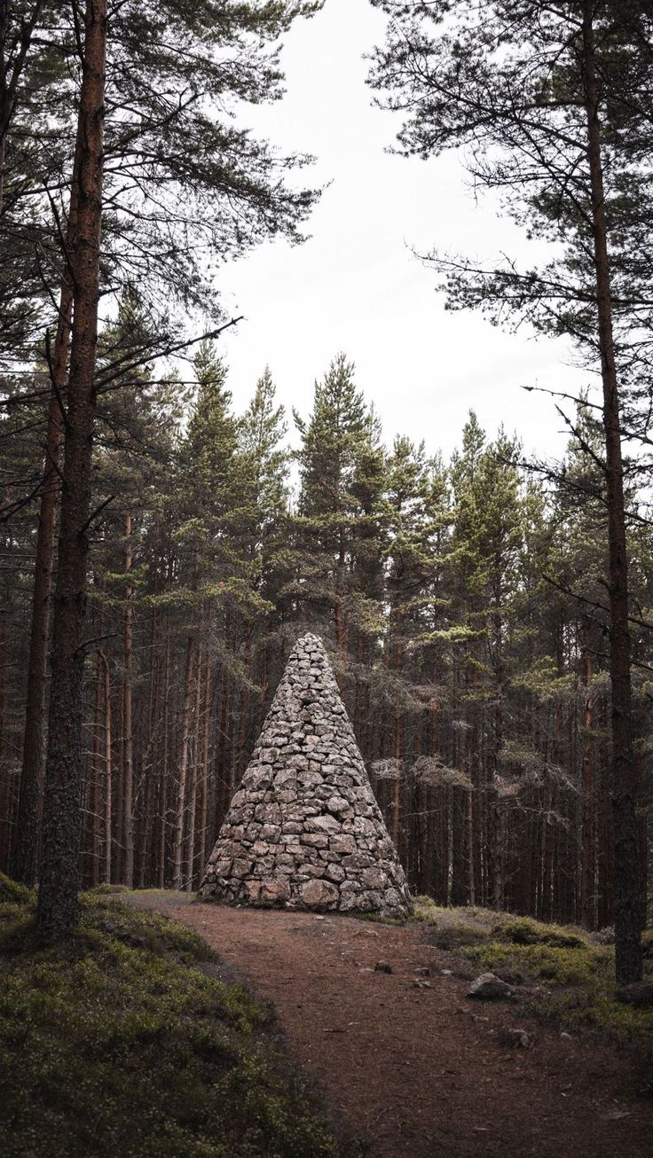 a stone pyramid in the middle of a forest