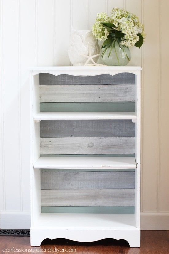 a white book shelf with flowers on top