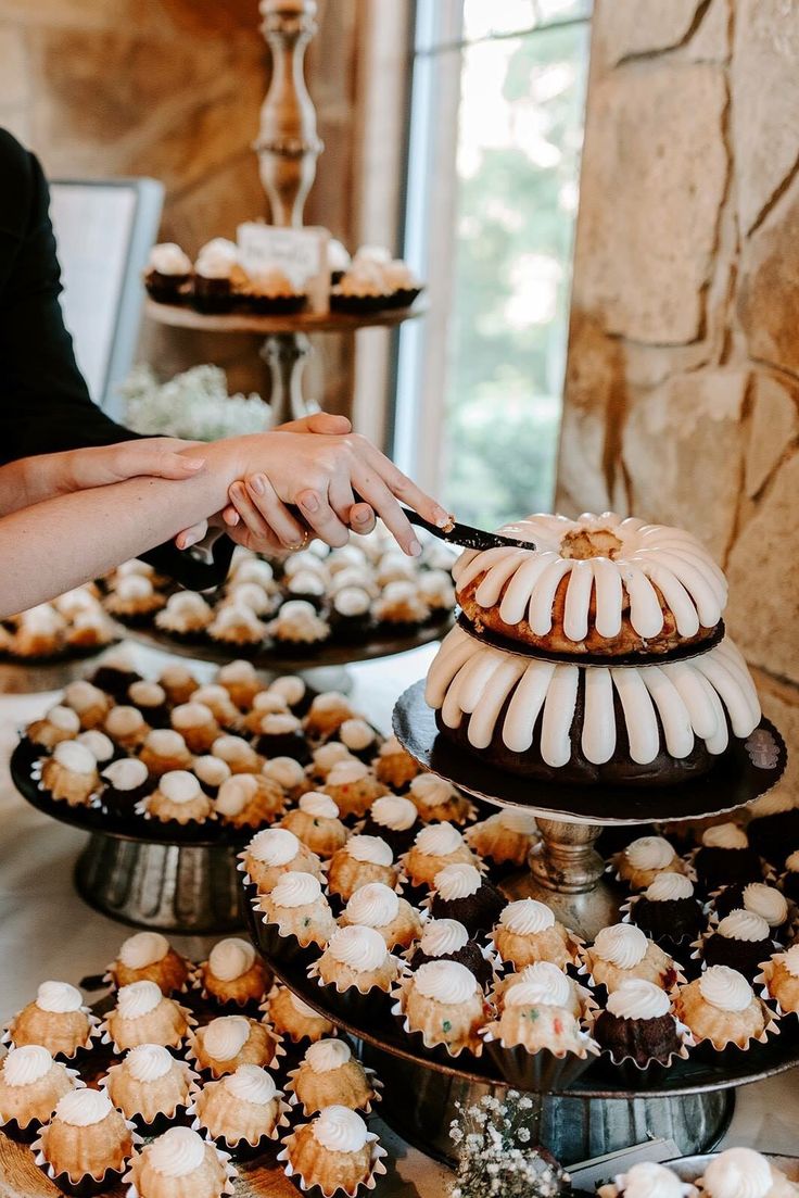 a table topped with lots of cakes and cupcakes