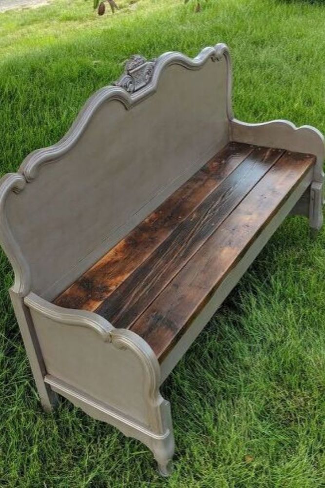 the bench is made out of wood and has an old style headboard on it