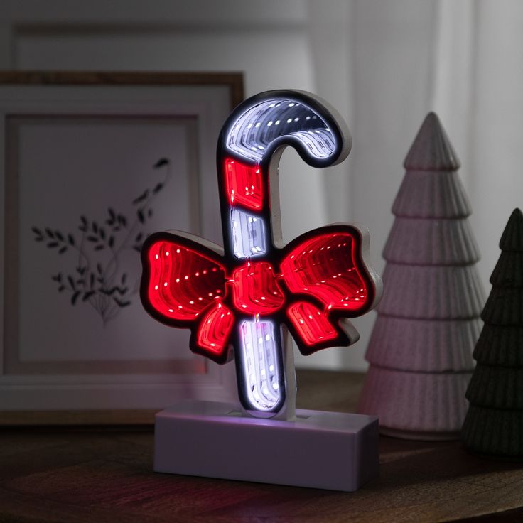 a lighted candy cane with a red bow on it