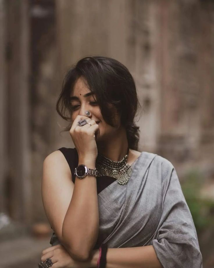 a woman is talking on her cell phone while wearing a sari and bracelets